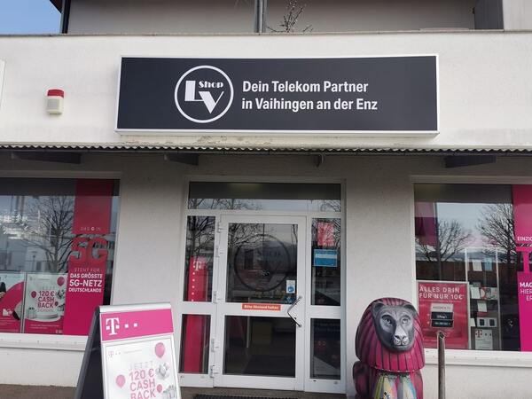 Telekom Shop in Vaihingen an der Enz mit Werbeschildern und bunter Löwenfigur am Eingang.
