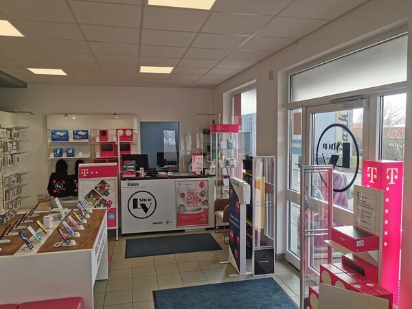 Modernes Telekommunikationsgeschäft mit Smartphones, Zubehör und Beratungstheke im Innenraum.